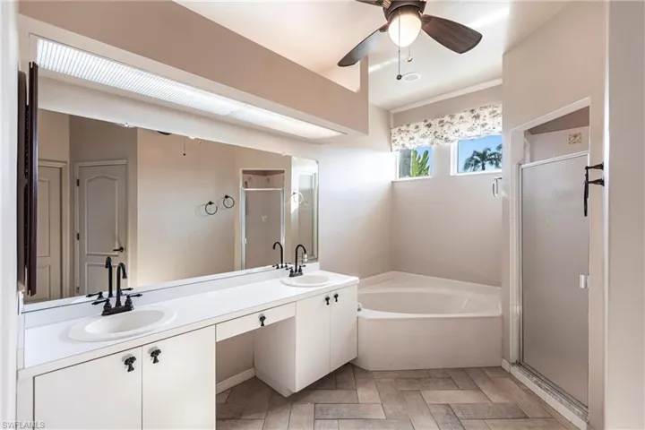 Bathroom featuring vanity, plus shower, soaking garden tub and ceiling fan and custom Imported Italian Tile, too!