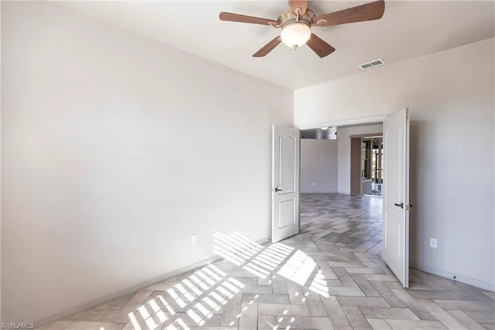 Looking out from den to living room and lanai with ceiling fan.