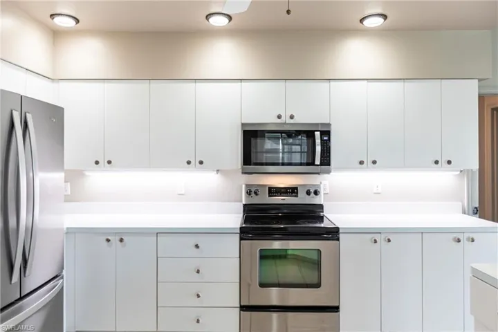 Kitchen featuring appliances with stainless steel finishes and white cabinets.