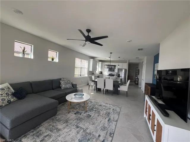 Living area featuring a ceiling fan and baseboards