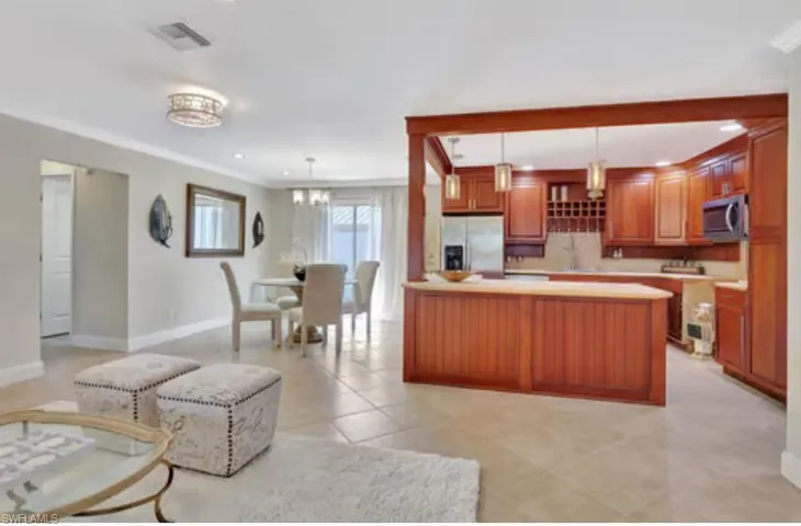 Kitchen featuring light tile patterned floors, visible vents, light countertops, appliances with stainless steel finishes, and decorative light fixtures