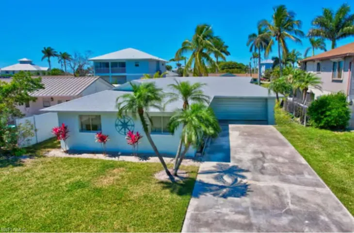View of front of house with a front lawn, fence, a garage, and driveway