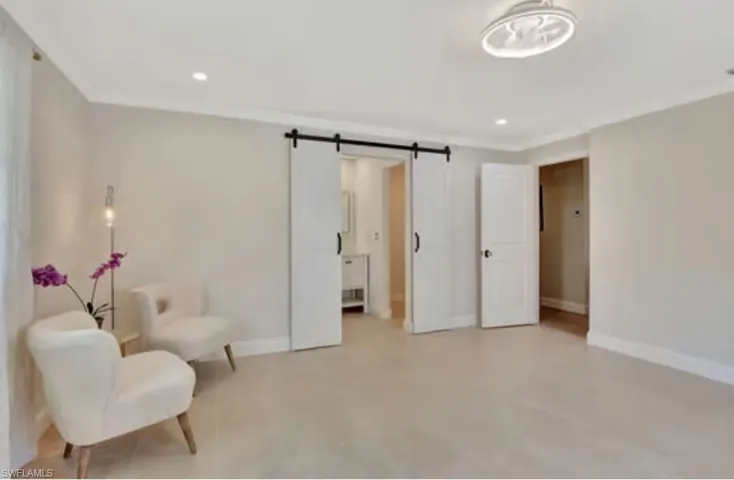 Sitting room featuring recessed lighting, baseboards, and a barn door