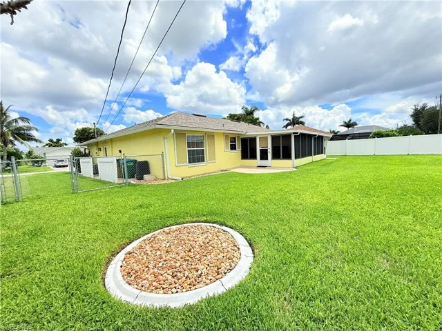 Back of property with a fenced backyard, a sunroom, stucco siding, a gate, and a patio