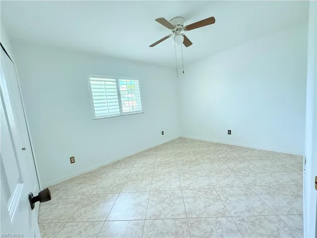 Spare room with ceiling fan and light tile patterned flooring