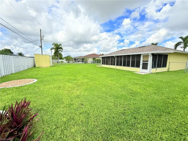 Fenced backyard with a sunroom and an outdoor structure