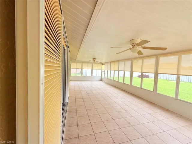 Unfurnished sunroom featuring a ceiling fan
