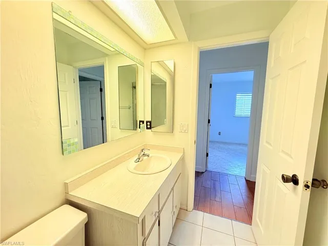Half bathroom featuring vanity and light tile patterned flooring
