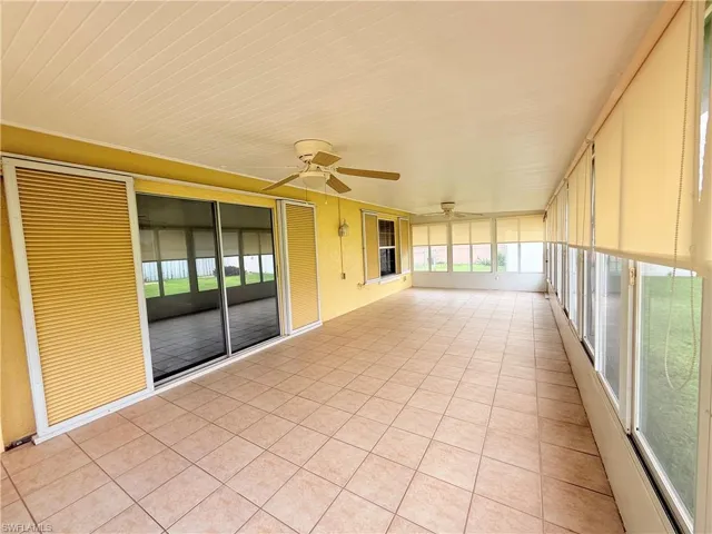 Unfurnished sunroom with a ceiling fan and plenty of natural light