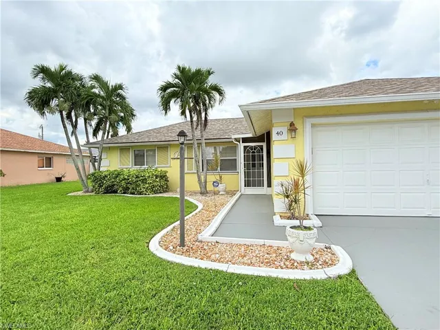 Single story home featuring roof with shingles, a front lawn, concrete driveway, a garage, and stucco siding