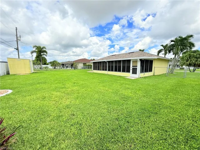 Fenced backyard with a sunroom and a storage unit