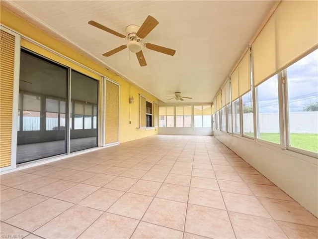 Unfurnished sunroom with a ceiling fan and plenty of natural light