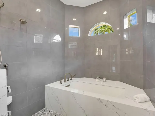 Spa like tub and shower with transom windows to bring in natural light