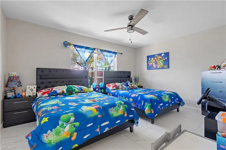 Bedroom with marble finish floors and a ceiling fan