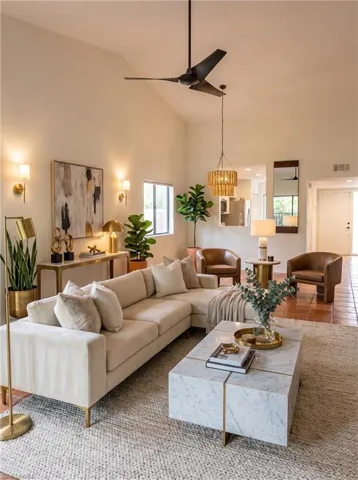 Vaulted ceiling living area featuring a modern ceiling fan, recessed lighting, wall sconces, and terracotta tile flooring