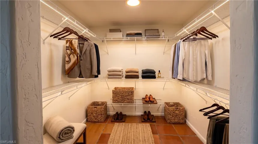 Walk-in closet featuring ample wire shelving, hanging rods, recessed lighting, and terracotta tile flooring
