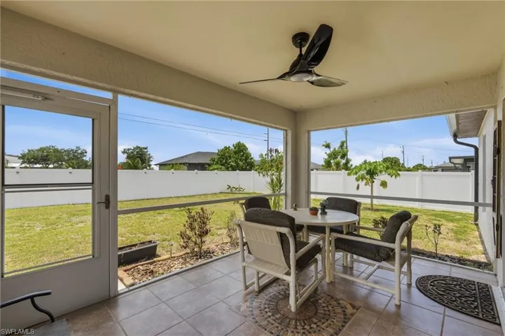Screened patio featuring tile flooring and a ceiling fan