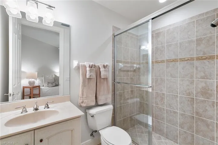 Ensuite bathroom featuring a stall shower and vanity