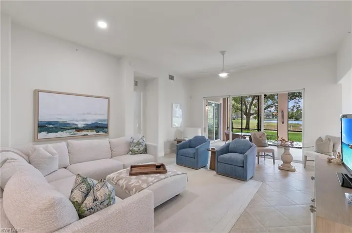 Tiled living area with recessed lighting and ceiling fan