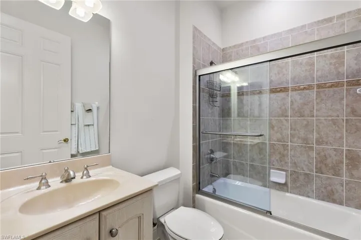 Bathroom with enclosed tub / shower combo and vanity