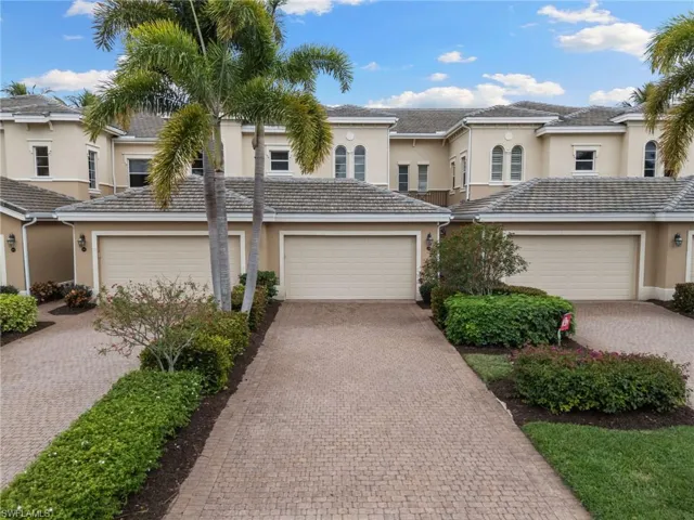 View of front of house featuring stucco siding, decorative driveway, and a garage