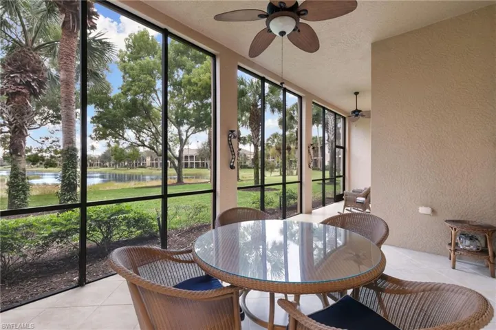 Sunroom with ceiling fan, outdoor dining space, and a water view