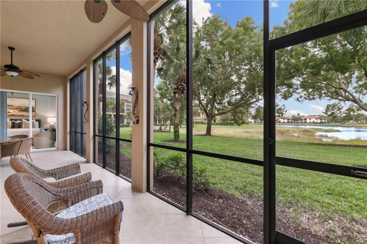 Sunroom / solarium featuring a ceiling fan and a water view