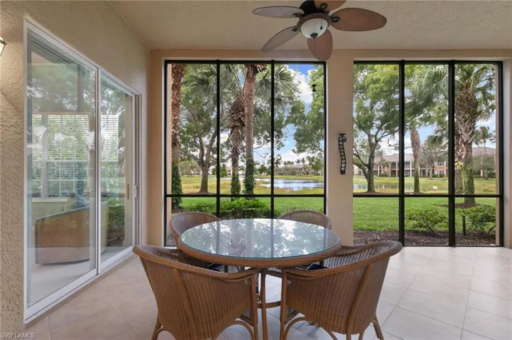 Sunroom featuring a textured wall, a water view, a textured ceiling, and tile patterned flooring