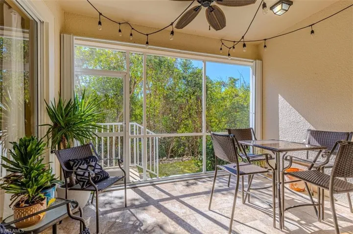 Sunroom / solarium featuring a textured wall, stone tile flooring, and plenty of natural light