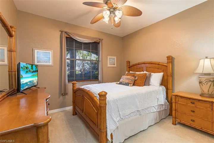 Bedroom with light carpet, a ceiling fan, and a textured wall