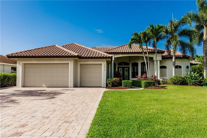 Mediterranean / spanish-style home featuring a front lawn and a garage