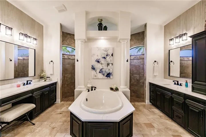 Bathroom featuring tile floors, independent shower and bath, double vanity, and ornate columns
