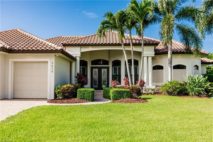 Mediterranean / spanish-style home featuring a front yard and a garage