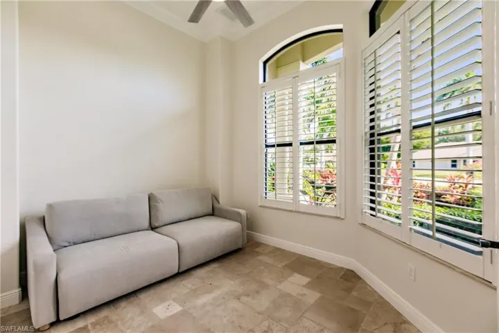 Sitting room featuring crown molding, a wealth of natural light, ceiling fan, and light tile floors