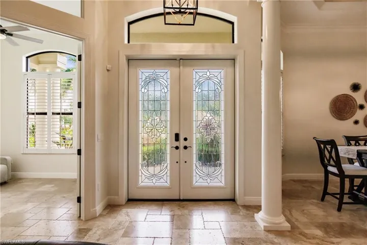 Entryway with french doors, ornamental molding, ceiling fan, and light tile floors