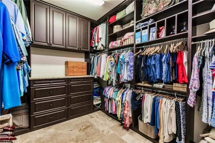 Walk in closet featuring light tile floors