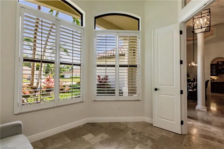 Living area with tile flooring and ornate columns