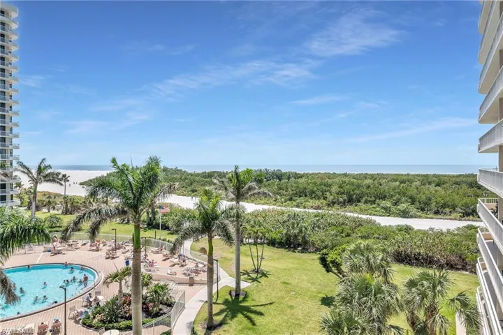 Community pool with a patio, a lawn, and a water view