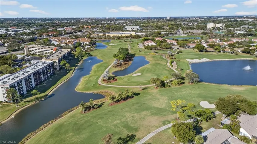 Aerial view of property's location featuring a local golf course and a large body of water
