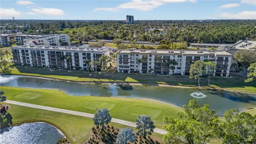 Drone / aerial view of apartment complex and a local golf course