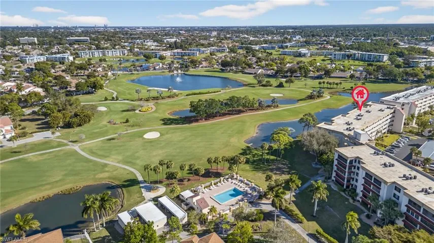 Aerial overview of property's location featuring a golf course and a nearby body of water