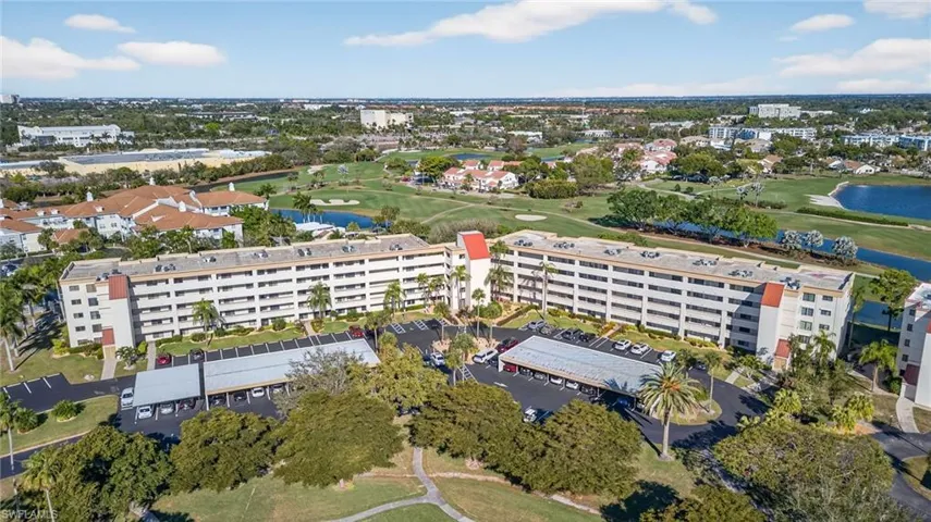 Aerial view of property's location featuring a local golf course and a large body of water
