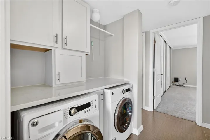 Laundry area with washing machine and clothes dryer, cabinet space, and carpet flooring