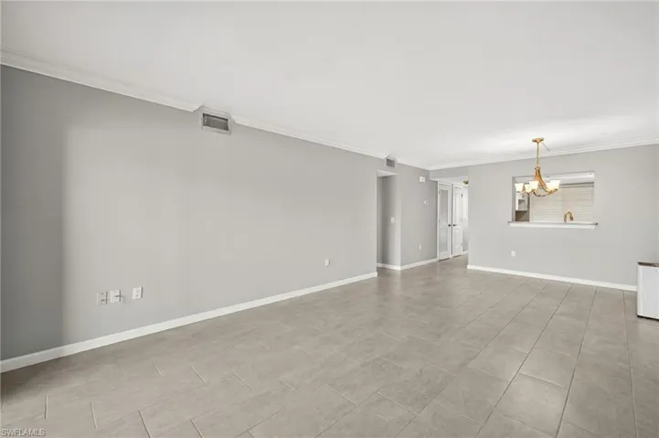 Unfurnished room with ornamental molding and a chandelier