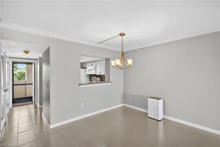 Unfurnished dining area featuring crown molding and a chandelier