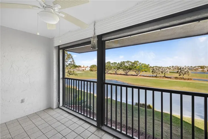 Unfurnished sunroom featuring ceiling fan, golf course view, a water view, and a balcony