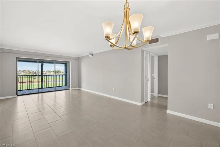 Unfurnished room featuring crown molding and a chandelier