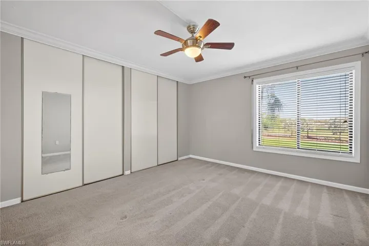 Unfurnished bedroom featuring crown molding, light carpet, a ceiling fan, and a closet