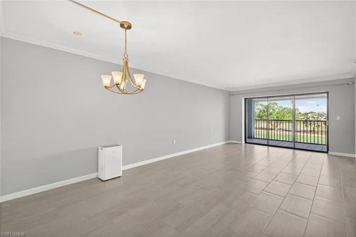Spare room featuring ornamental molding and a chandelier