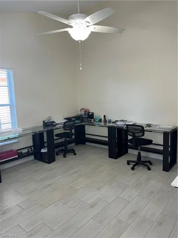 Office space with wood tiled floors, a ceiling fan, and high vaulted ceiling